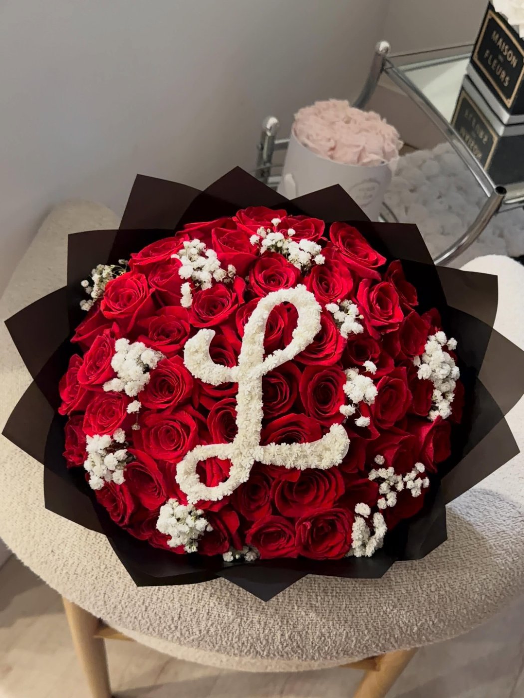 Preserved roses in keepsake hat boxes beside a fresh red rose bouquet