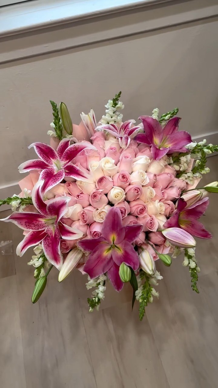 A lush bouquet of pink stargazer lilies, blush roses and white snapdragons