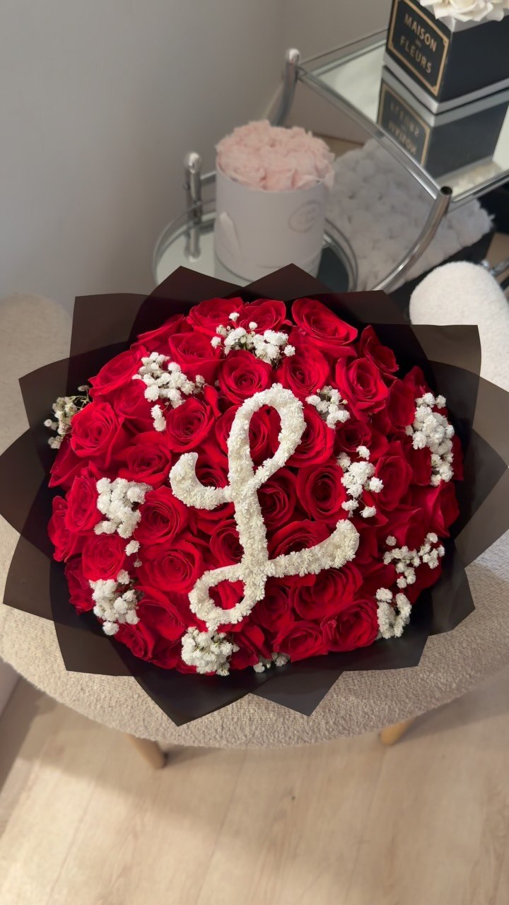 Red roses with a cursive baby's-breath letter monogram