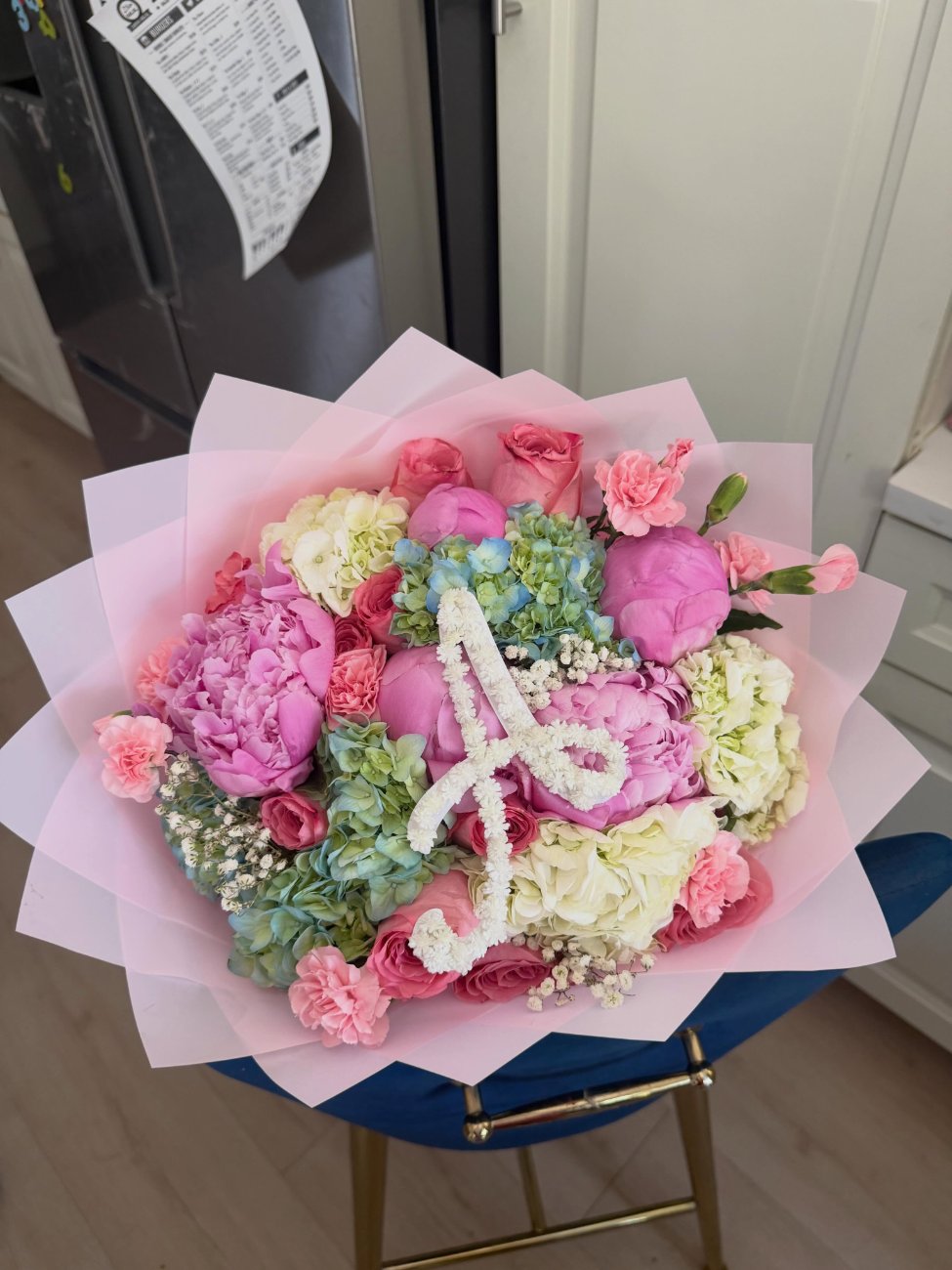 Pink peonies, roses and hydrangea with a baby's-breath monogram, wrapped in blush